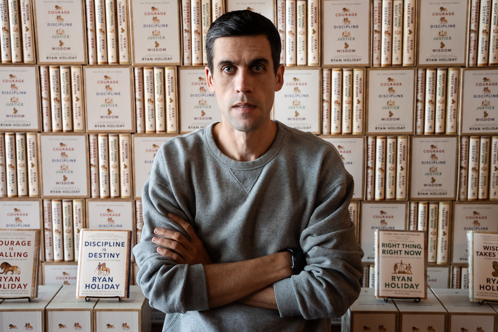 Ryan Holiday standing in front of his Stoic Virtues book series